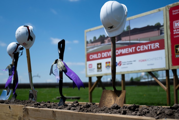 Shovels stand straight up in dirt.