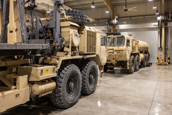 Two U.S. military vehicles await delivery following repairs in a U.S. Army Corps of Engineers Expeditionary District constructed Tactical Equipment Maintenance Facility, in the U.S. Central Command area of operations.