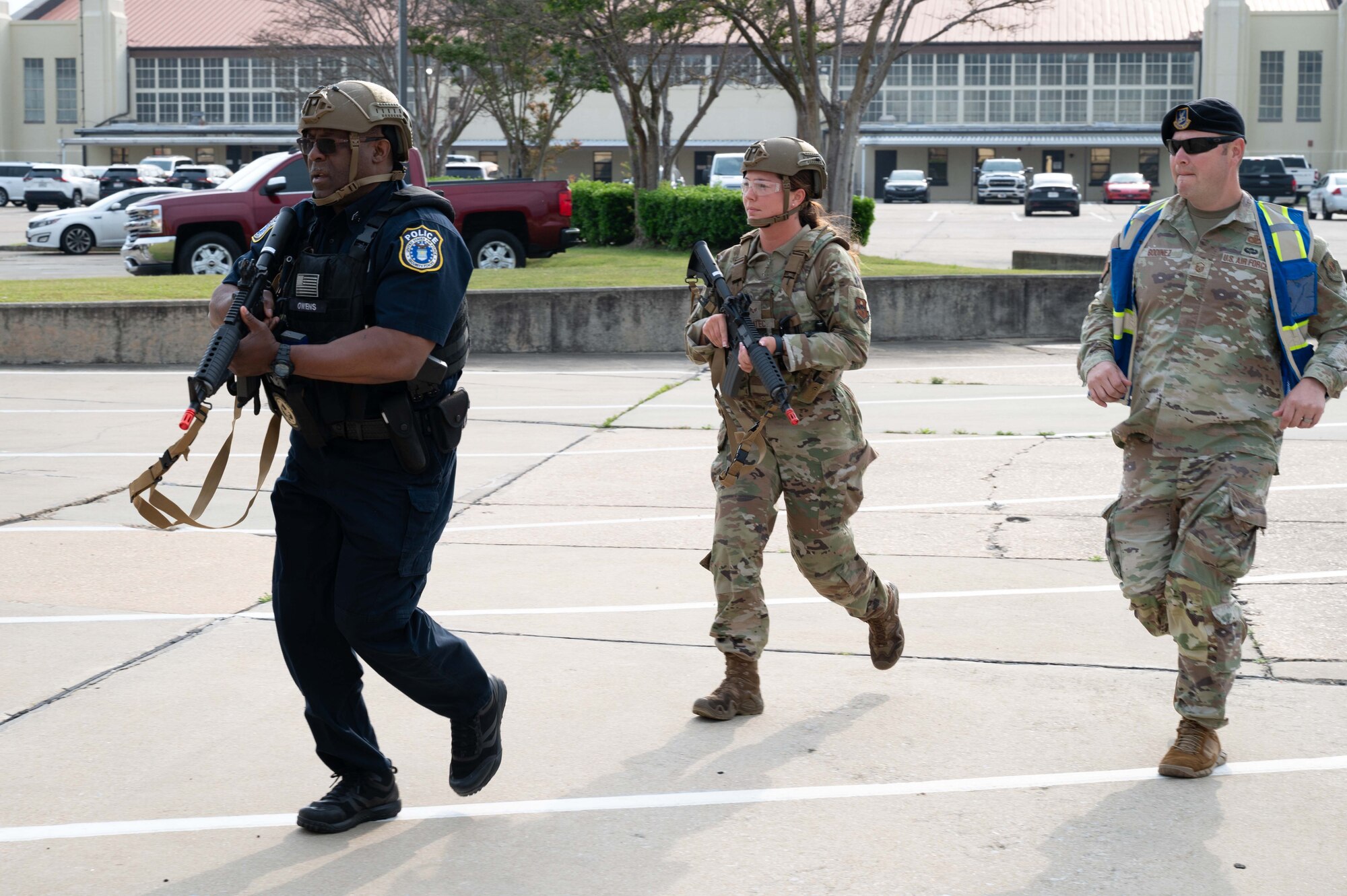From left, Donnel Owens, 42nd Security Forces Squadron police officer, U.S. Air Force Senior Airman Jaden Bohatec, 42nd SFS military working dog handler, and Master Sgt. Eric Godinez, 42nd SFS standards and tactics chief, run toward a scene during an active shooter drill at Maxwell Air Force Base, Alabama, April 15, 2025.
