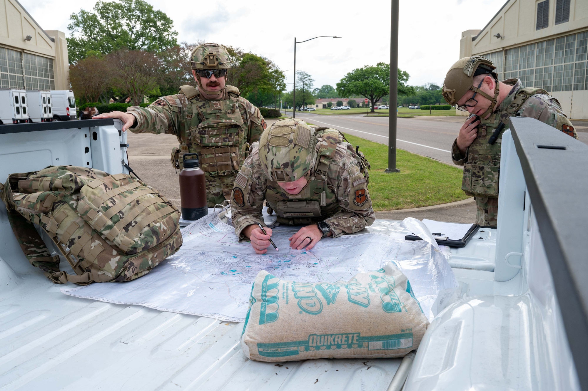 From left, U.S. Air Force Master Sgt. Scott Brakefield, 42nd Security Forces Squadron kennel master, Tech Sgt. Jordan Layton, 42nd SFS flight chief, and Tech Sgt. Travis Jordan, 42nd SFS flight chief, plan an entry point for a MAXFORCE active shooter exercise at Maxwell Air Force Base, Alabama, April 15, 2025