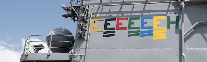 USS America proudly displays a newly painted golden “E” with a silver star above it, symbolizing its fifth consecutive Battle Effectiveness Award. USS America earned the Battle “E” Award every year she was forward-deployed to U.S. Naval Forces in Japan.