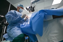 U.S. Army Maj. Sien Chen, Brooke Army Medical Center cataract eye surgeon, and U.S. Air Force Maj. Samuel Hobbs, 59th Medical Wing vitreoretinal surgeon (right), collaborate during a procedure at Georgetown Public Hospital, Guyana, April 3, 2025 during the Lesser Antilles Medical Assistance Team (LAMAT) 2025 mission.