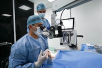 U.S. Army Maj. Sien Chen, Brooke Army Medical Center cataract eye surgeon, and U.S. Air Force Maj. Samuel Hobbs, 59th Medical Wing vitreoretinal surgeon (right), collaborate during a procedure at Georgetown Public Hospital, Guyana, April 3, 2025 during the Lesser Antilles Medical Assistance Team (LAMAT) 2025 mission.