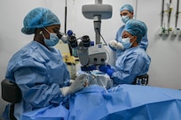 Dr. Arlene Bobb-Semple, Georgetown Public Hospital vitreoretinal surgeon performs a procedure with guidance from U.S. Air Force Maj. Samuel Hobbs, 59th Medical Wing vitreoretinal surgeon (right), at Georgetown Public Hospital, Georgetown, Guyana, April 3, 2025 during the Lesser Antilles Medical Assistance Team (LAMAT) 2025 mission.