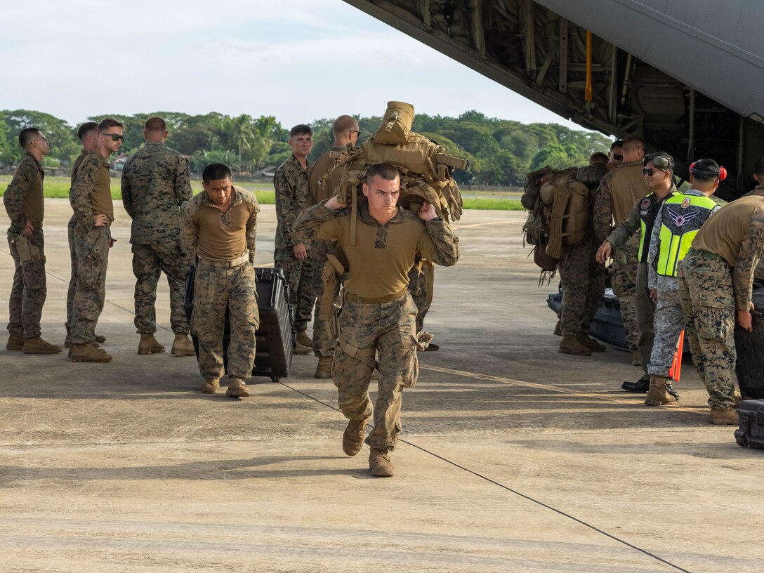 U.S. Marines with 2nd Battalion, 1st Marine Regiment, Marine Rotational Force – Darwin 25.3 unload cargo from a U.S. Air Force C-130J with 36th Airlift Squadron, 374th Airlift Wing after their arrival to Puerto Princesa, Palawan, Philippines, from Mindanao for Balikatan 2025, April 15, 2025. Balikatan is a longstanding annual exercise between U.S. and Philippine armed forces designed to strengthen the alliance, showcase the capable combined force, and demonstrate the commitment to regional security and stability. (U.S. Marine Corps photo by Sgt. Ezekieljay Correa)