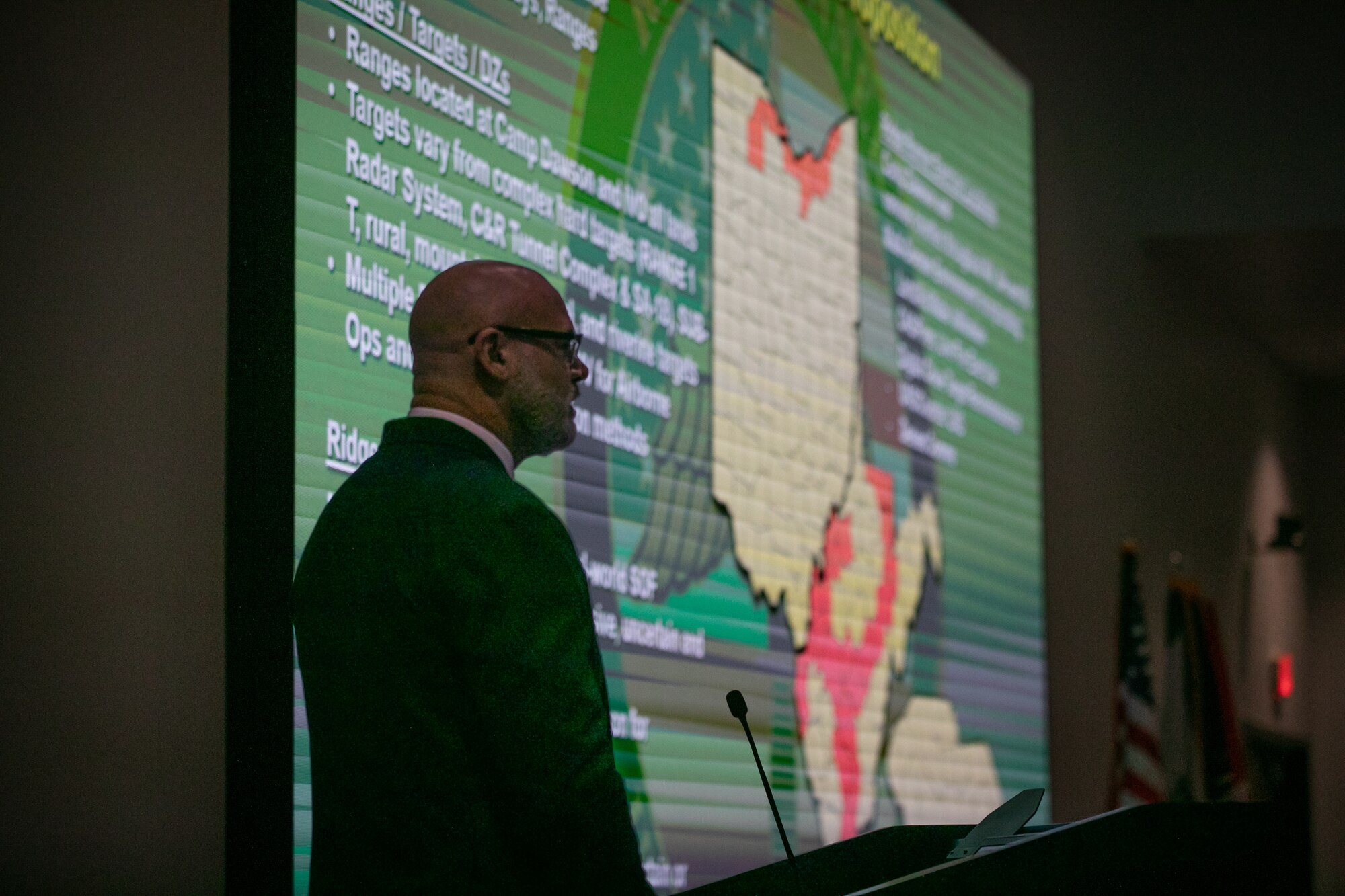 man silhouetted in front of large map