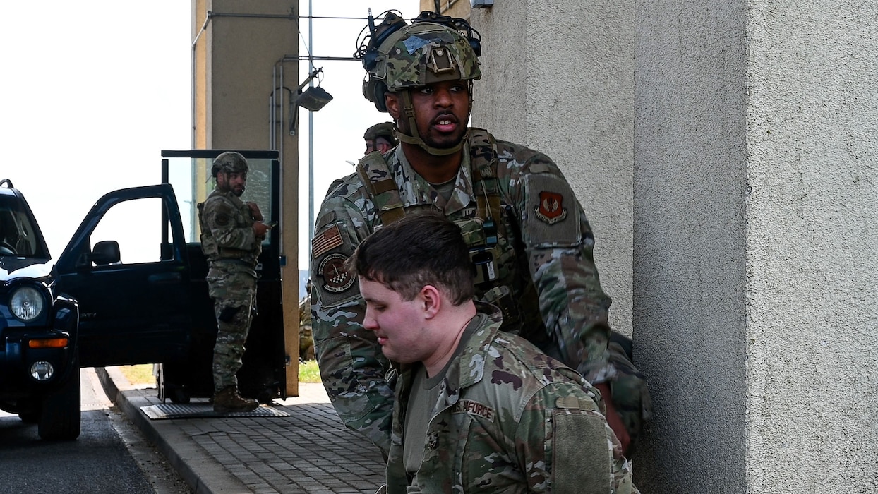 U.S. Air Force Senior Airman Derek Denson, 52nd Security Forces Squadron defender, subdues a simulated malicious actor during Exercise Swift Saber 25 at Spangdahlem Air Base, Germany, April 22, 2025. The scenario validated the defenders’ ability to successfully complete a high risk traffic stop and minimize the threat’s impact on 52nd Fighter Wing operations. Exercises like Swift Saber 25 enhance the 52nd Fighter Wing’s warfighting capabilities by validating Agile Combat Employment concepts such as rapid threat response, dispersed operations and mission generation in contested environments. (U.S. Air Force photo by Staff Sgt. Max J. Daigle)