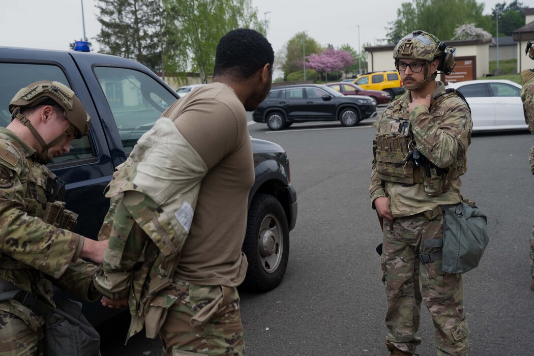 Defenders assigned to the 52nd Security Forces Squadron subdue a simulated malicious actor during an insider threat scenario involving an F-16 Fighting Falcon as part of Exercise Swift Saber 25 at Spangdahlem Air Base, Germany, April 22, 2025. 52nd SFS defenders were tested on their ability to identify, respond to and neutralize simulated threats throughout the combat readiness exercise. Swift Saber 25 strengthens the 52nd Fighter Wing’s warfighting capabilities by validating Agile Combat Employment concepts such as rapid threat response, dispersed operations and mission generation in contested environments. (U.S. Air Force photo by Senior Airman Darius Frazier)
