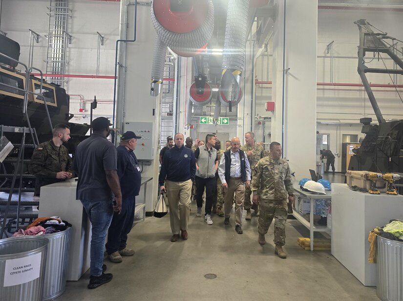 Army Field Support Battalion-Poland Commander Lt. Col. Omar McKen and Sgt. Maj. Olimpia Valdez lead U.S. House of Representatives Keith Self and Derek Tran and multiple House of Foreign Affairs Committee members, Congressional staffers and others through a maintenance facility at the Powidz Army Prepositioned Stocks-2 worksite in Poland April 16. (Cpt. James Bath)