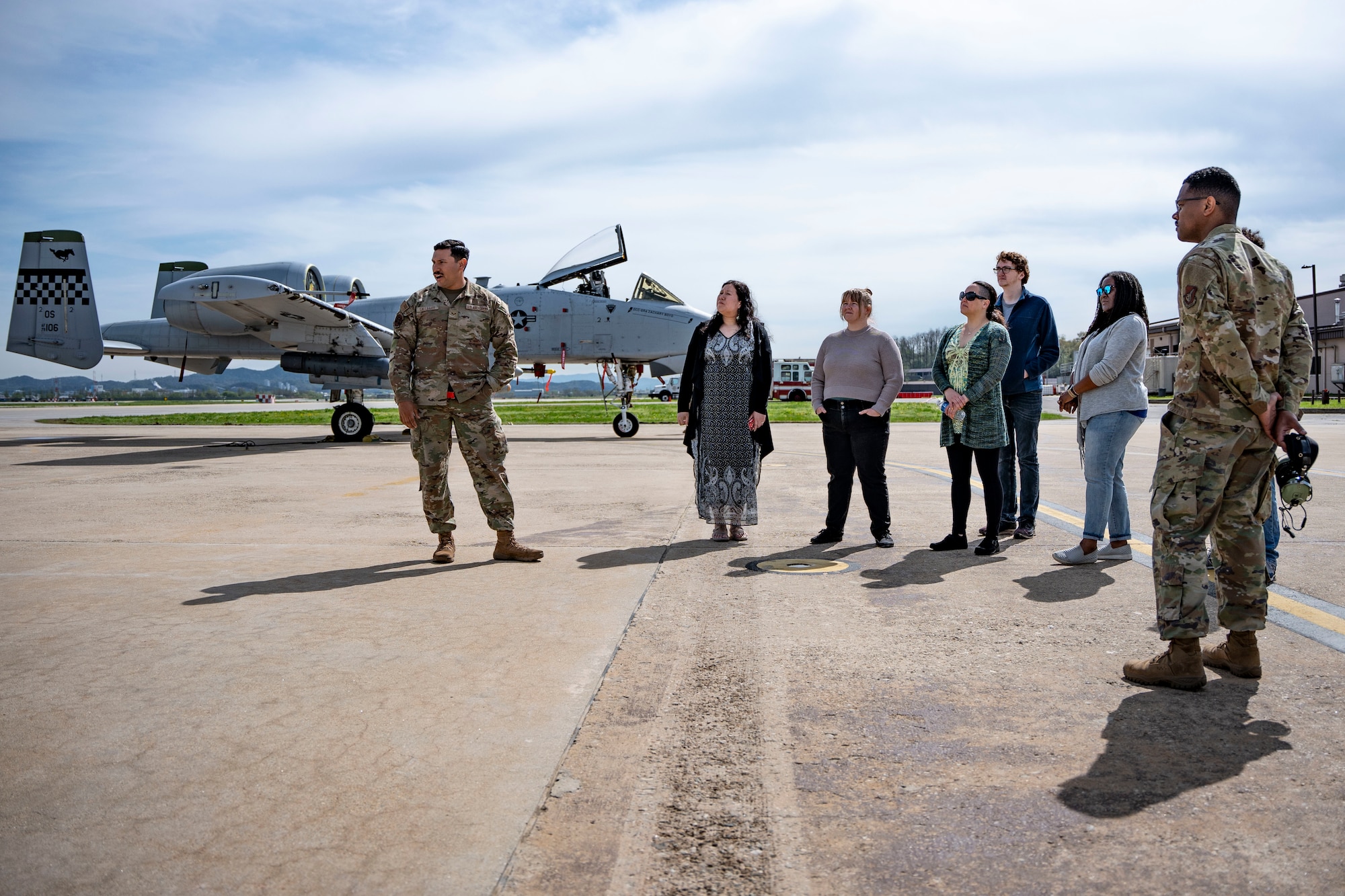 People stand in a semi circle listening to a presenter.
