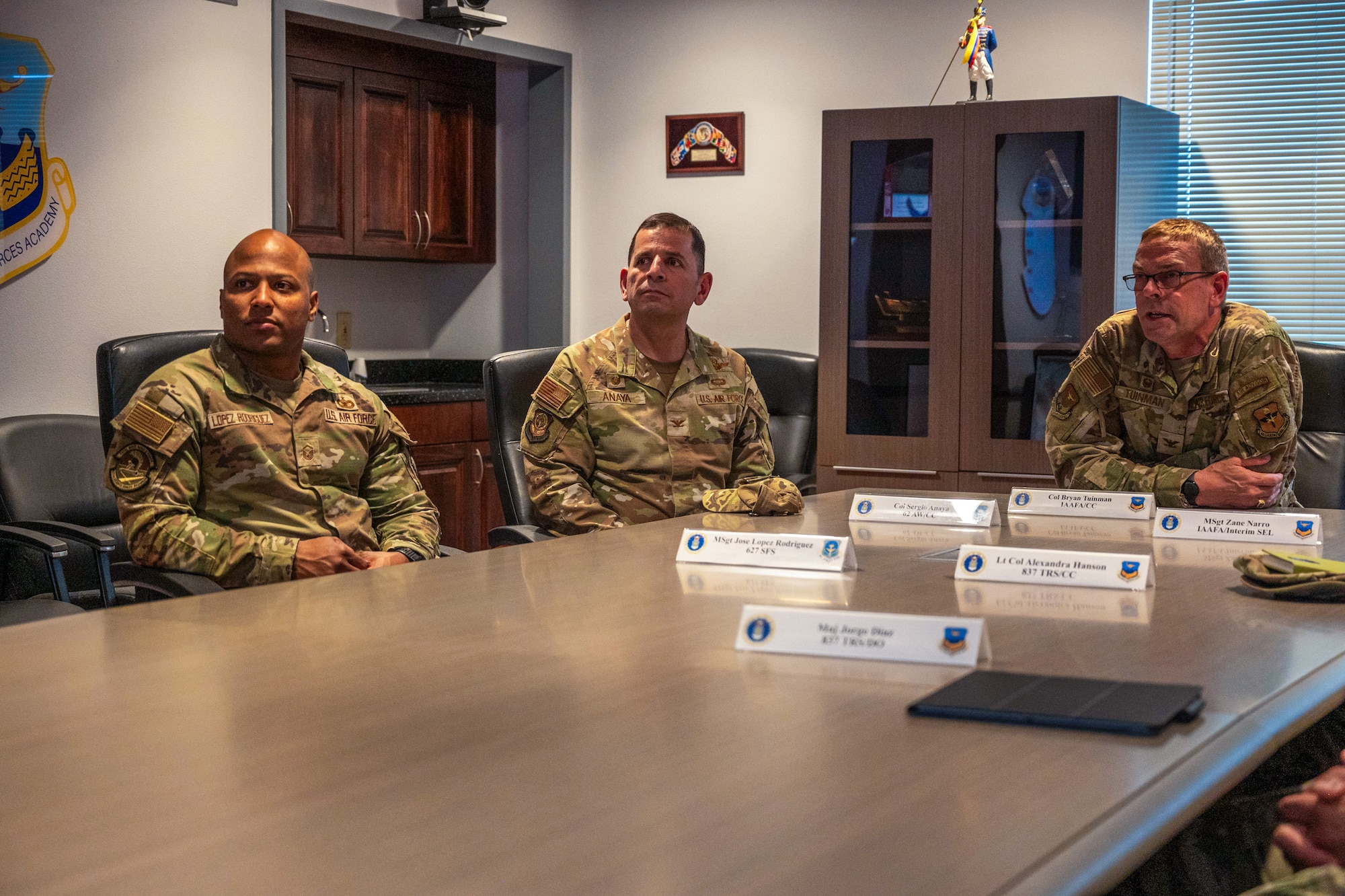 U.S. Air Force Col. Sergio Anaya, 62d Airlift Wing commander, center, and Master Sgt. José López Rodríguez, 627th Security Forces Squadron logistics and readiness superintendent, listen to a brief given by Col. Bryan Tuinman, Inter-American Air Forces Academy commander, at the Inter-American Air Forces Academy at Joint Base San Antonio-Lackland, Texas, April 9, 2025.