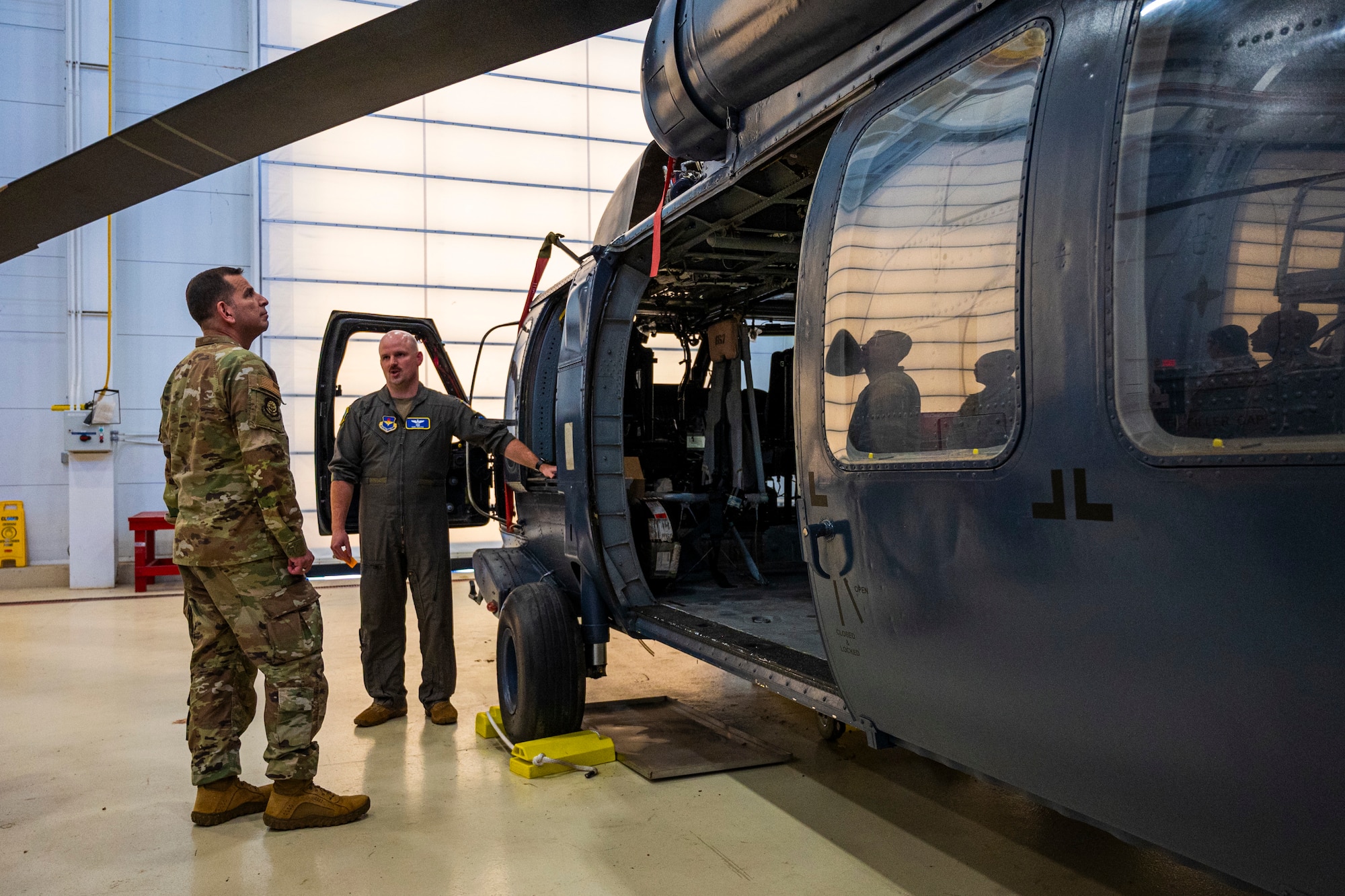U.S. Air Force Col. Sergio Anaya, 62d Airlift Wing commander, center, and Lt. Col. Cary Reeves, 318th Training Squadron director of operations, discuss Sikorsky UH-60 Black Hawk training at the Inter-American Air Forces Academy at Joint Base San Antonio-Lackland, Texas, April 9, 2025.