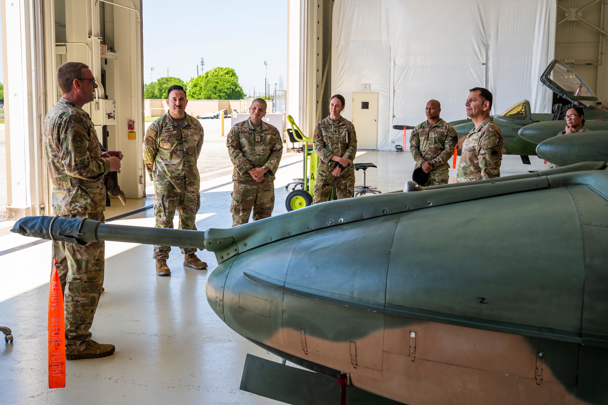 U.S. Air Force Col. Sergio Anaya, 62d Airlift Wing commander, second from the right, Col. Bryan Tuinman, Inter-American Air Forces Academy commander, left, IAAFA staff members, and Master Sgt. José López Rodríguez, 627th Security Forces Squadron logistics and readiness superintendent, third from the right, discuss IAAFA’s history at Joint Base San Antonio-Lackland, Texas, April 9, 2025.