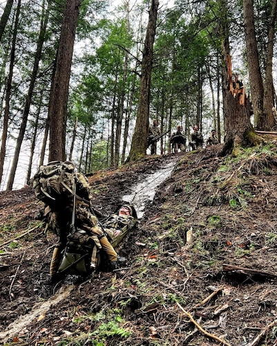 A Soldier practices evacuating a casualty on a steep slope