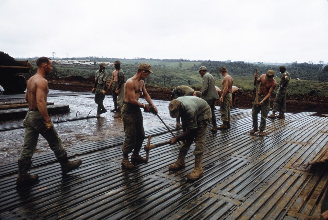 B Co, 14th Engr Bn are shown here placing M8A1 solid steel matting at Bao Loc. This is a C- 130 runway which will be operational by the end of the month.