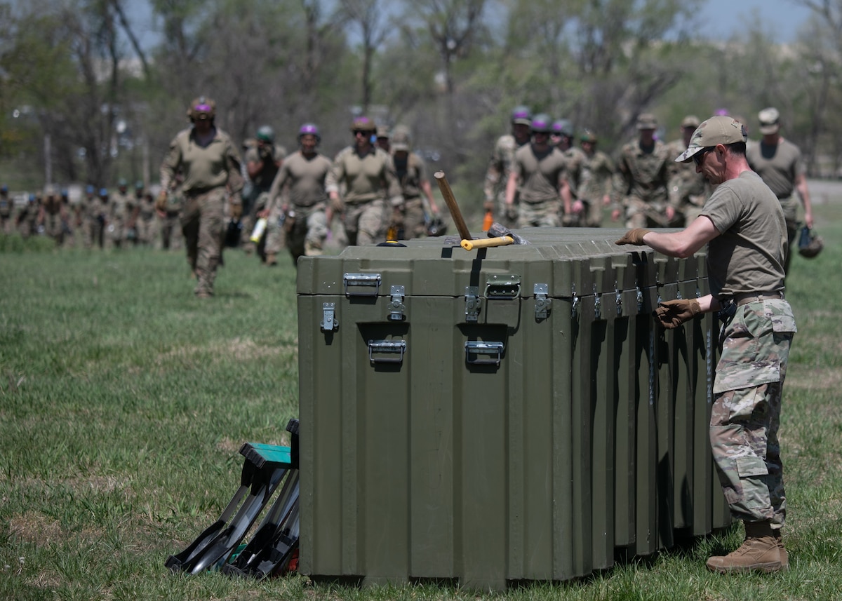 Airmen from the 22nd Civil Engineer Squadron race to their respective containers for the tent-building challenge during the 22nd CES Battle of the Bulls competition at McConnell Air Force Base, Kansas, April 17, 2025. Each team required every member to touch the container before they could begin constructing their tents. (U.S. Air Force photo by Senior Airman Amelio Brown)