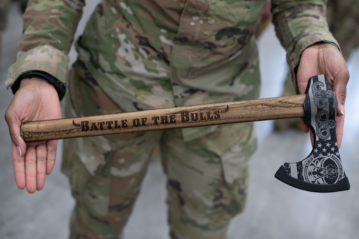 An Airman assigned to the 22nd Civil Engineer Squadron displays the trophy for the 22nd CES Battle of the Bulls competition at McConnell Air Force Base, Kansas, April 17, 2025. The engraved tomahawk was awarded to the Blue Team to commemorate their win. (U.S. Air Force photo by Senior Airman Amelio Brown)
