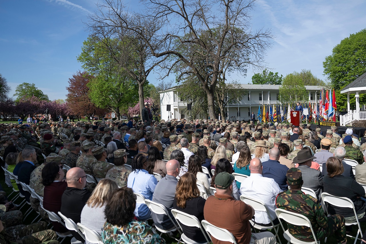 A large seated crowd during daylight.