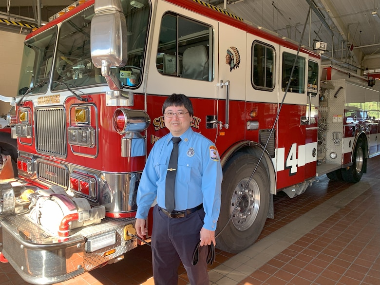 Man stand in front of fire truck.