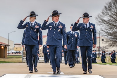 Air Force military training instructors lead formation of graduates at Air Force Officer Training School class 24-06 graduation parade.