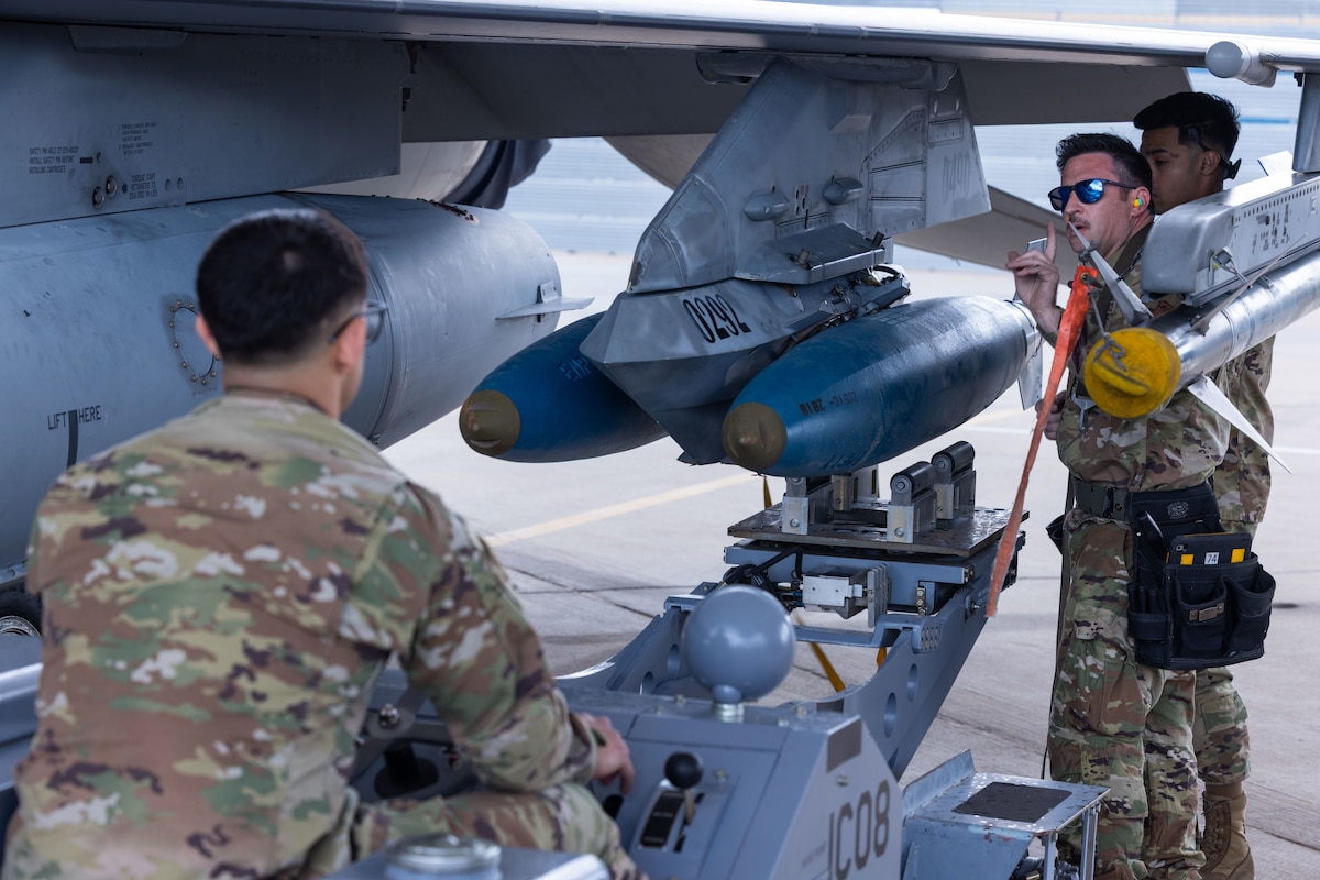 U.S. Air National Guard members assigned to the 162nd Wing load a BDU-50, a 500 pound training munition onto an F-16 during the 2025 Weapons Load Competition at Morris Air National Guard Base, Ariz., Apr. 4, 2025. The annual competition sharpens warfighting readiness by testing every aspect of weapons loading-from tool accountability to precise safety wire placement. (U.S. Air National Guard photo by Tech. Sgt. Hampton Stramler)