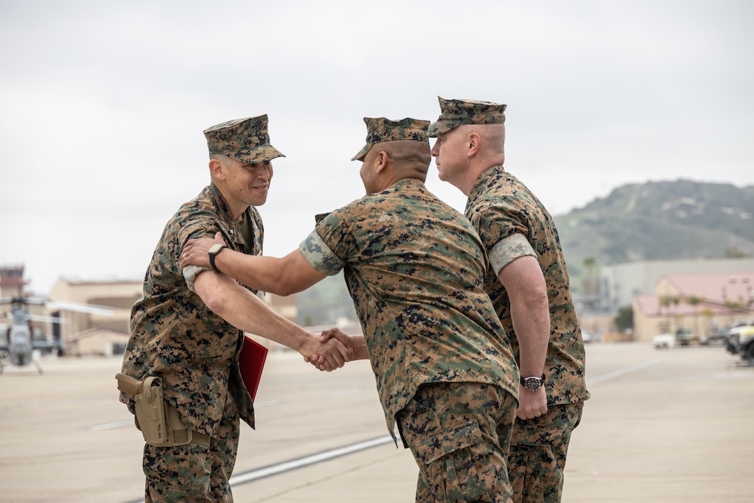 U.S. Marine Corps Lt. Col. Mark R. Mauberret, left, the outgoing commanding officer of Marine Light Helicopter Attack Squadron 775, Marine Aircraft Group 41, 4th Marine Aircraft Wing, shakes hands with Sgt. Maj. Willie Lucero, center, the senior enlisted advisor for HMLA-775, MAG-41, during a change of command ceremony at Marine Corps Air Station Camp Pendleton, Calif., April 13, 2025. During the ceremony, Lt. Col. Mark R. Mauberret relinquished command of HMLA-775 to Lt. Col. Jack R. Guevara. The ceremony represents the transfer of authority, responsibility, and accountability from the outgoing officer to the incoming commanding officer. (U.S. Marine Corps photo by Lance Cpl. Mhecaela J. Watts)