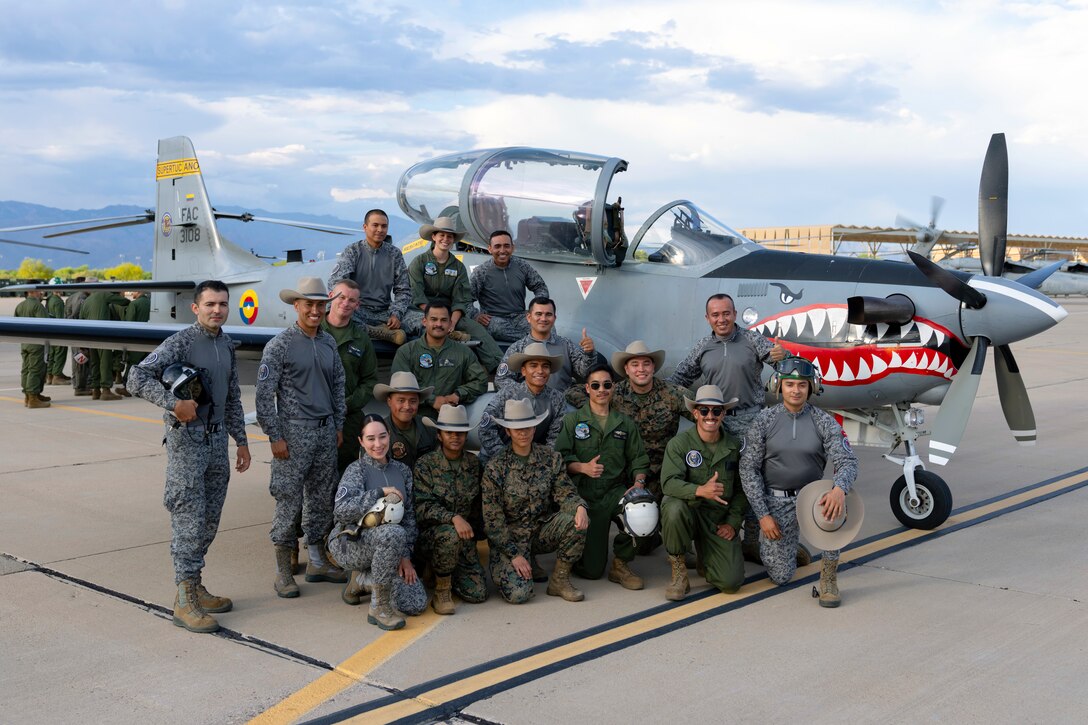 Colombian Air Force technicians and U.S. Marine Corps personnel pose for a photo with an A-29B Super Tucano aircraft during an exchange between Red Flag-Rescue 23-1 exercise participants at Davis-Monthan Air Force Base, Ariz., May 16, 2023. This year marked the third consecutive time Fuerza Aérea Colombiana (FAC) partners have participated in the DoD's premier combat search and rescue exercise. (U.S. Air Force Photo by Tech. Sgt. Rachel Maxwell)