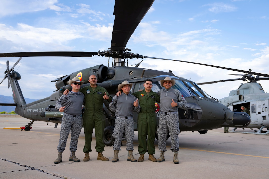 Colombian Air Force technicians and U.S. Marine Corps personnel pose for a photo with an AH-60L Arpía helicopter during an exchange between Red Flag-Rescue 23-1 exercise participants at Davis-Monthan Air Force Base, Ariz., May 16, 2023. This year marked the third consecutive time Fuerza Aérea Colombiana (FAC) partners have participated in the DoD's premier combat search and rescue exercise, and the first involvement of the FAC AH-60L Arpía helicopter. (U.S. Air Force Photo by Tech. Sgt. Rachel Maxwell)