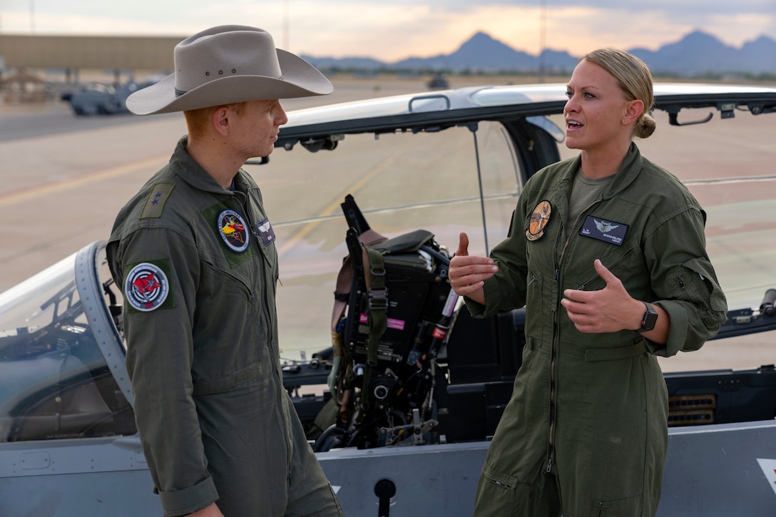 A U.S. Marine and Colombian Air Force aircrew member speak on the wing of an A-29B Super Tucano aircraft during an exchange between Red Flag-Rescue 23-1 exercise participants at Davis-Monthan Air Force Base, Ariz., May 16, 2023. Exercises like Red Flag-Rescue present opportunities to build regional capacity with partner nations by enhancing cooperation, collaboration, and interoperability in a joint environment. (U.S. Air Force Photo by Tech. Sgt. Rachel Maxwell)