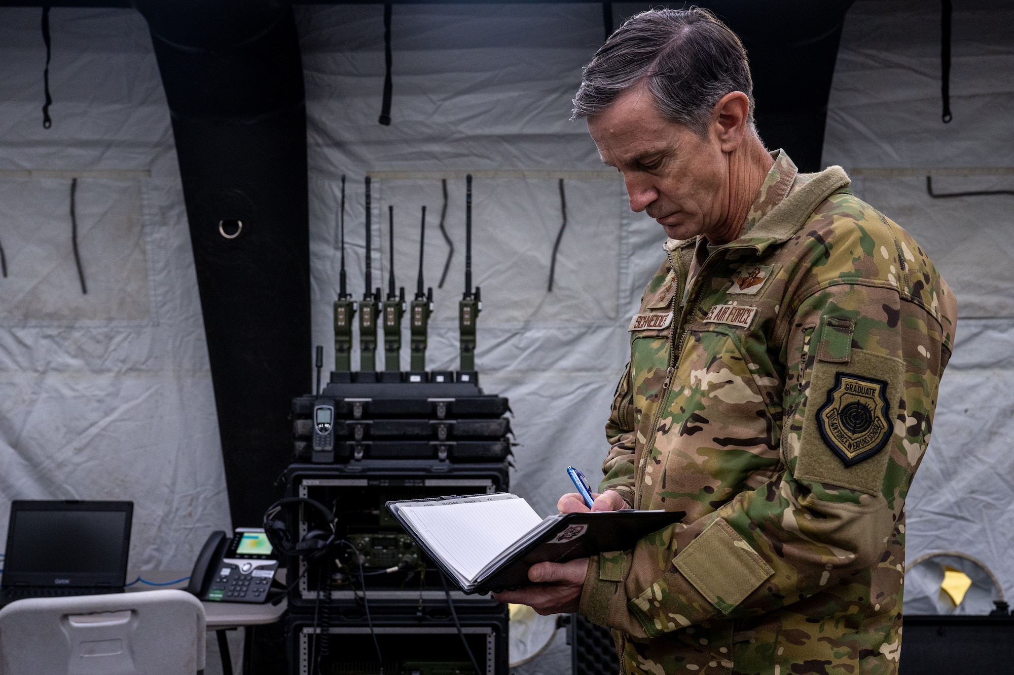 U.S. Air Force Gen. Kevin Schneider, Pacific Air Forces commander, takes notes while visiting the 3rd Air Expeditionary Wing to discuss Agile Combat Employment operations at Hangar 2 on Joint Base Elmendorf-Richardson, Alaska, April 10.