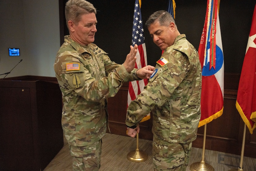 U.S. Army Maj. Gen. Phil Ryan, left, the U.S. Army South (USARSOUTH) ceremonially welcomes Chilean army Maj. Gen. Eduardo Valdivia, the incoming deputy commanding general – interoperability, during a patching ceremony in the unit’s Daniel Van Voorhis Conference Room at Fort Sam Houston, Texas, April 22, 2022.  The patching ceremony is a tradition meant to welcome incoming leaders to USARSOUTH. (U.S. Army photo by Sgt. 1st Class ShaTyra Cox)