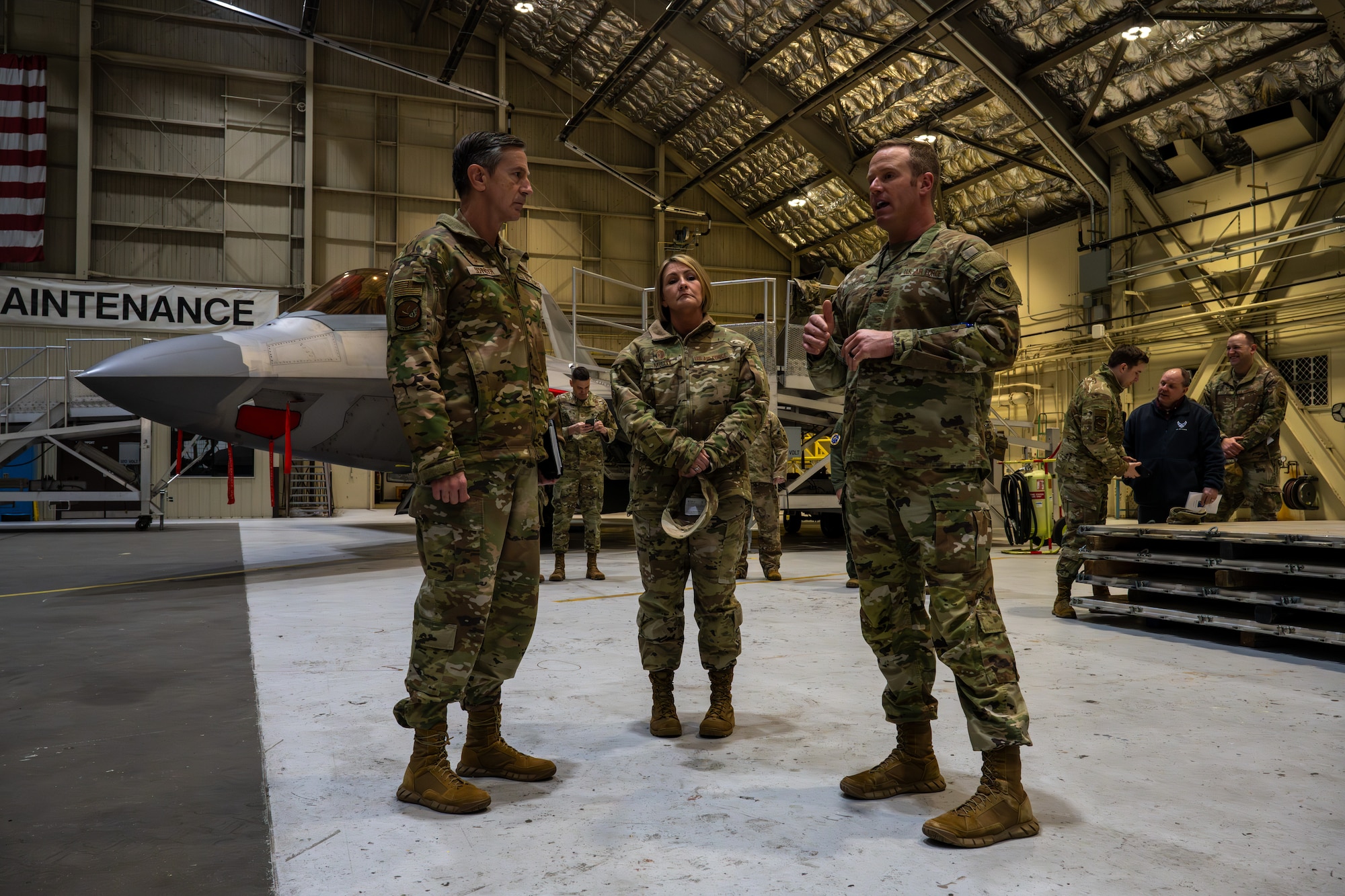 From left: U.S. Air Force Gen. Kevin Schneider, Pacific Air Forces commander; Chief Master Sgt. Katie McCool, PACAF command chief master sergeant; and Lt. Col. Travis Lytton, 3rd Maintenance Group deputy commander, discuss the 3rd Air Expeditionary Wing and Agile Combat Employment operations at Hangar 2 on Joint Base Elmendorf-Richardson, Alaska, April 10.
