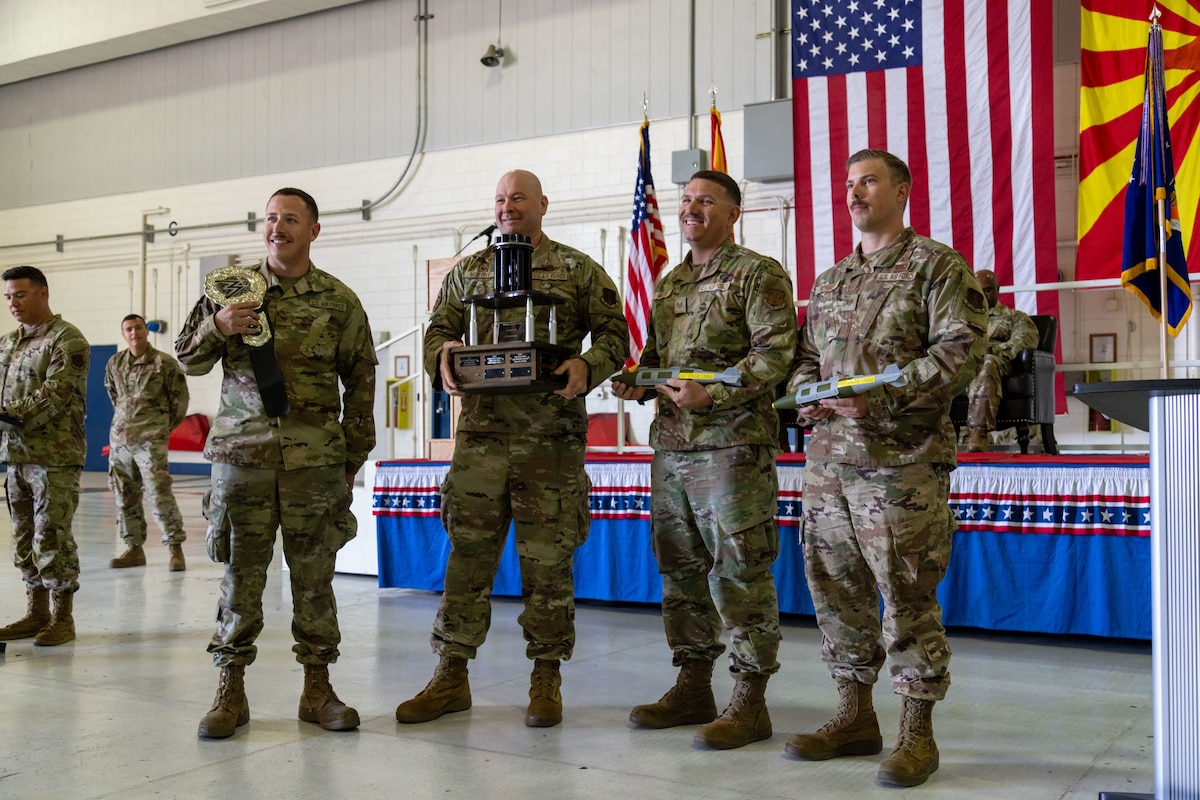 .S. Air National Guard members gather for a photo during the Wing Awards ceremony at Morris Air National Guard Base, Ariz., Apr. 6, 2025. The 21st Fighter Squadron weapons load crew were named 'Load Crew of the Year' for the second year in a row. (U.S. Air National Guard photo by Tech. Sgt. Stephen Luke)
