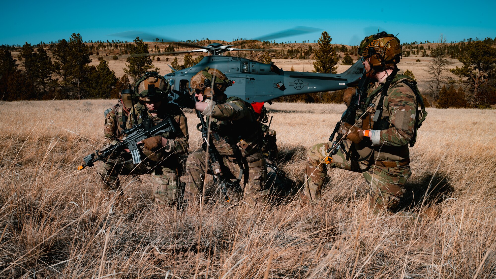 91st Missile Security Operations Squadron Tactical Response Force defenders prepare to advance uphill as a 550th Helicopter Squadron MH-139 Grey Wolf readies for takeoff during the Nuclear Convoy Course at Camp Guernsey Joint Training Center’s North Training Area, Wyoming, April 7, 2025. The 91 MSOS TRF air insertion marked the start of their participation in the NCC, a multi-day exercise sharpening convoy security, tactical response, and nuclear surety capabilities. (U.S. Air Force photo by Staff Sgt. Michael A. Richmond)