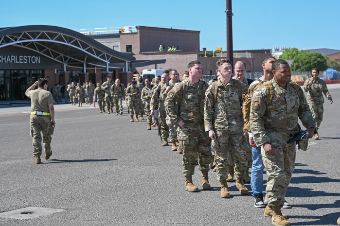 Airmen walking across the flightline to board an aircraft.