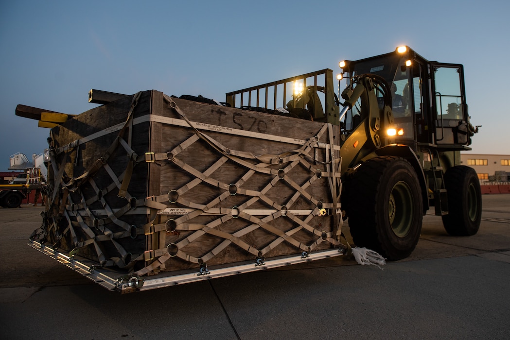 Airman on forklift dropping off cargo on flight line
