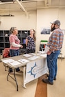 Heidi Anderson, and Patricia Leiataua, both career counselors, Command Career Center, speak with Cody Vandersluis, maintenance mechanic, Shop 06, Tooling and Maintenance, about career advancement, April 9, 2025, during a “pop-up” knowledge share event at Puget Sound Naval Shipyard & Intermediate Maintenance Facility in Bremerton, Washington. (U.S Navy photo by Jeb Fach)