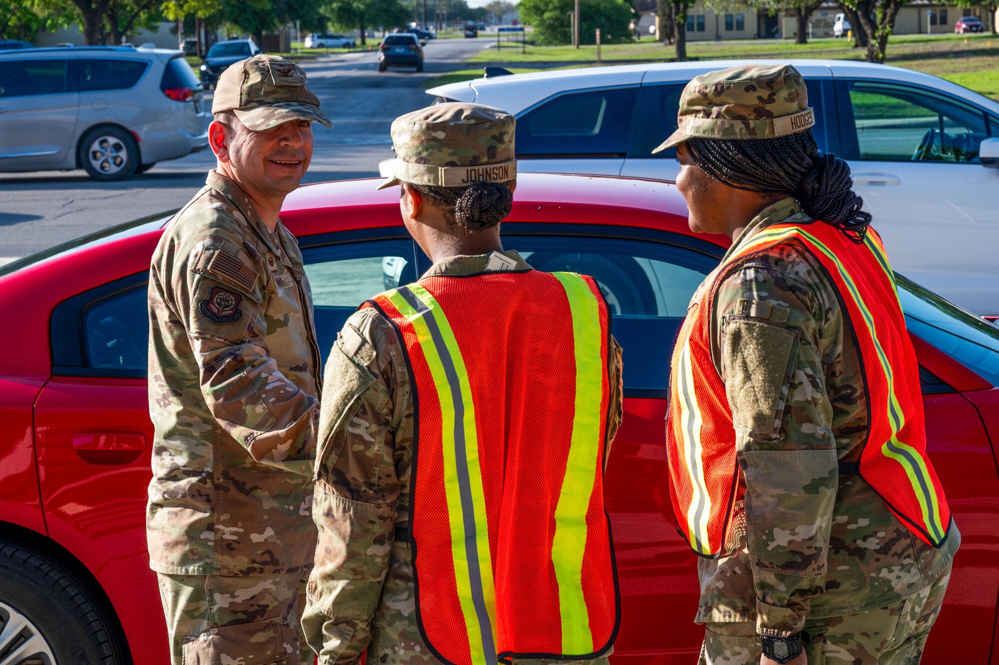 Two Basic Military Training trainees greet U.S. Air Force Col. Sergio Anaya, 62d Airlift Wing commander, in front of the Pfingston Reception Center at Joint Base San Antonio-Lackland, Texas, April 9, 2025.