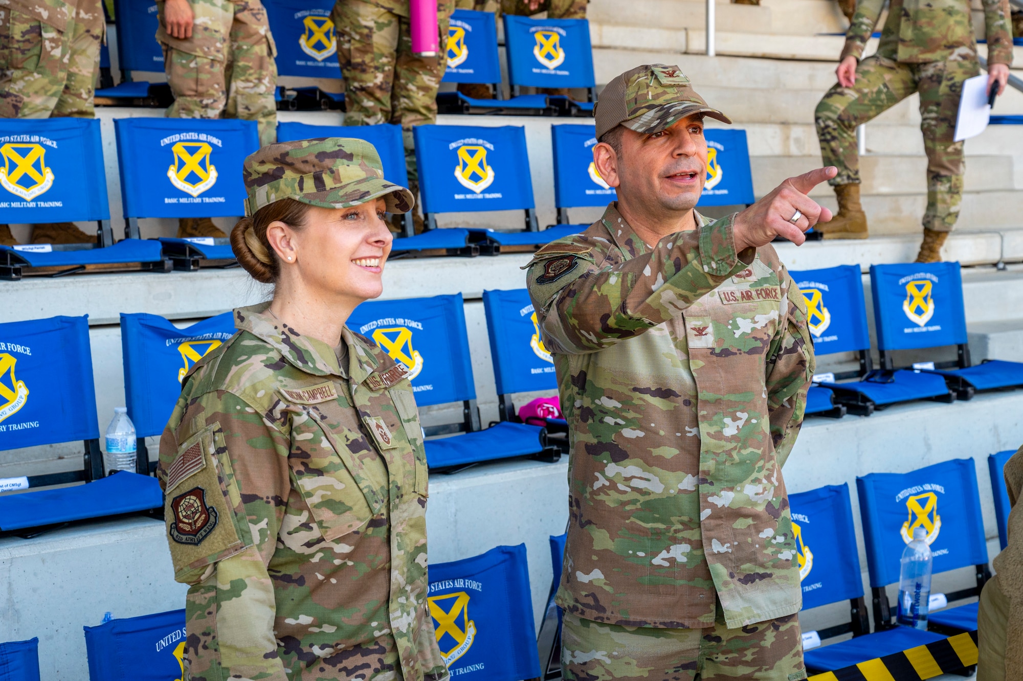 U.S. Air Force Col. Sergio Anaya, 62d Airlift Wing commander, and Chief Master Sgt. Kristy Korchak-Campbell, 62d AW command chief, converse before the Basic Military Training coin and retreat ceremony in the Pfingston Reception Center at Joint Base San Antonio-Lackland, Texas, April 9, 2025.