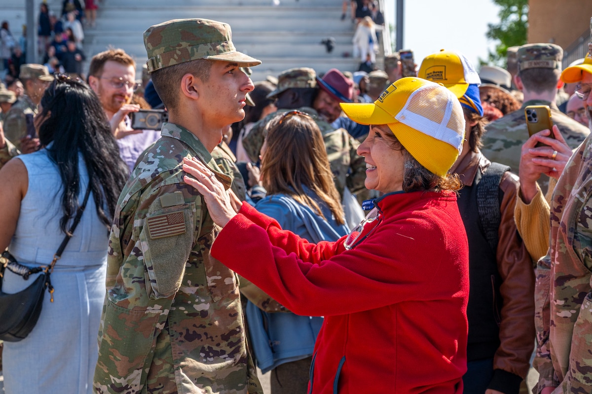 A loved one taps out their Airman following the Basic Military Training coin and retreat ceremony in the Pfingston Reception Center the at Joint Base San Antonio-Lackland, Texas, April 9, 2025.