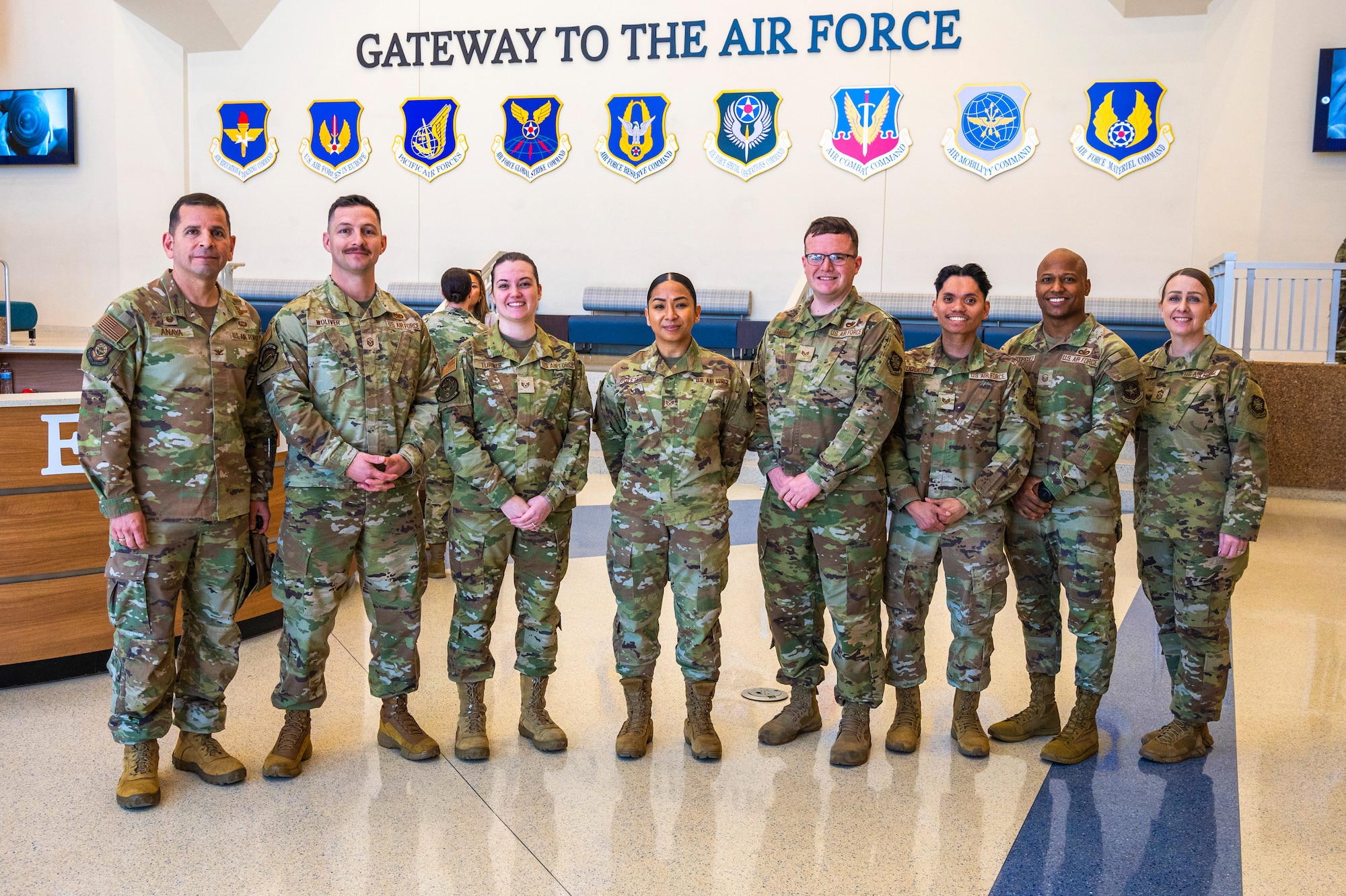 U.S. Air Force Col. Sergio Anaya, 62d Airlift Wing commander, Chief Master Sgt. Kristy Korchak-Campbell, 62d AW command chief, and a group of Team McChord NCOs stand together in the Pfingston Reception Center at Joint Base San Antonio-Lackland, Texas, April 9, 2025.