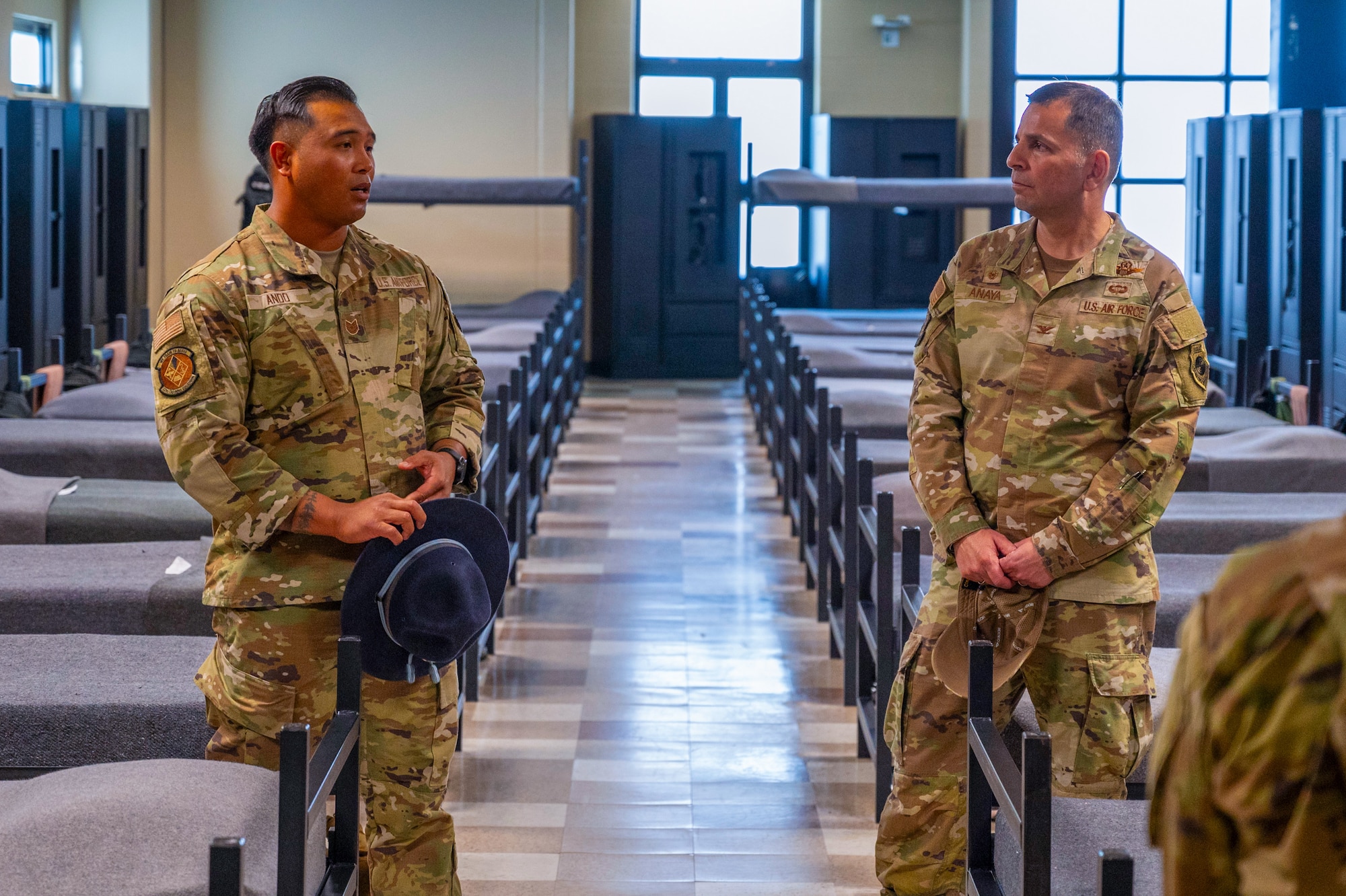 U.S. Air Force Col. Sergio Anaya, 62d Airlift Wing commander, right, listens to Tech. Sgt. Dangerard Ando, 331st Training Squadron master military training instructor, describe Basic Military Training trainee schedules at Joint Base San Antonio-Lackland, Texas, April 9, 2025.