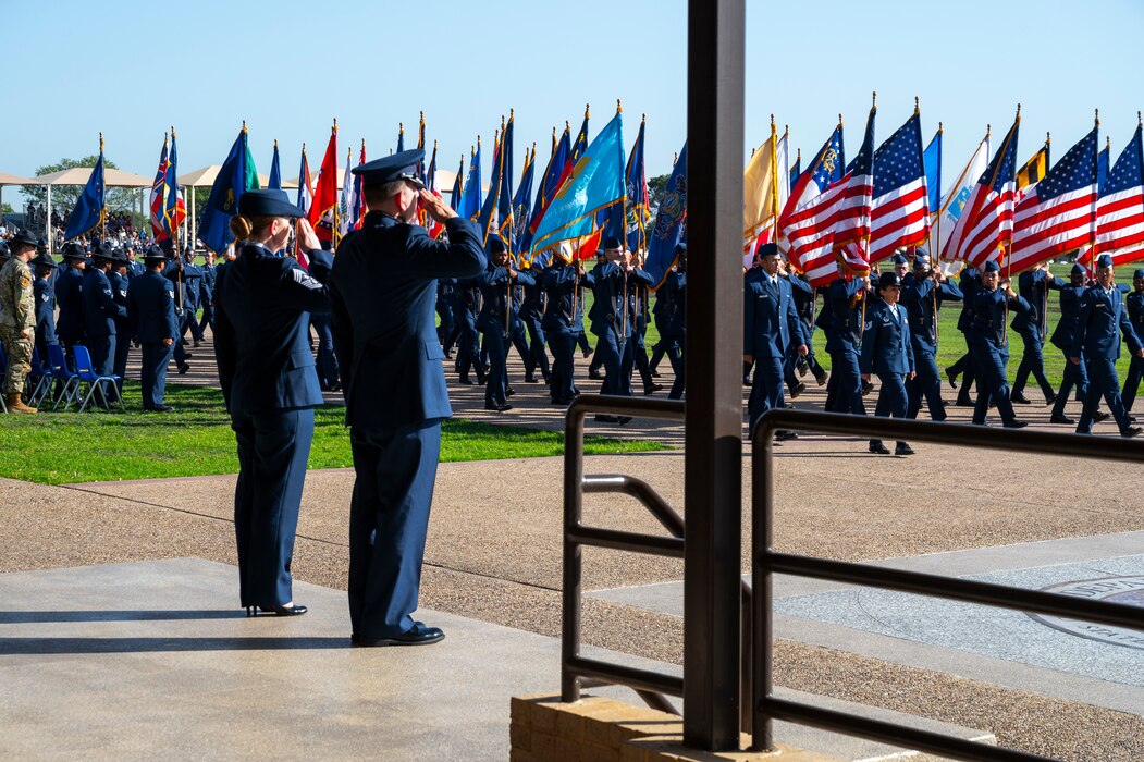 U.S. Air Force Col. Sergio Anaya, 62d Airlift Wing commander, and Chief Master Sgt. Kristy Korchak-Campbell, 62d AW command chief, salute the American flag during the Basic Military Training graduation parade pass in review at Joint Base San Antonio-Lackland, Texas, April 10, 2025.