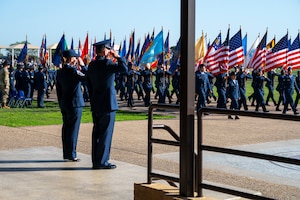 U.S. Air Force Col. Sergio Anaya, 62d Airlift Wing commander, and Chief Master Sgt. Kristy Korchak-Campbell, 62d AW command chief, salute the American flag during the Basic Military Training graduation parade pass in review at Joint Base San Antonio-Lackland, Texas, April 10, 2025.
