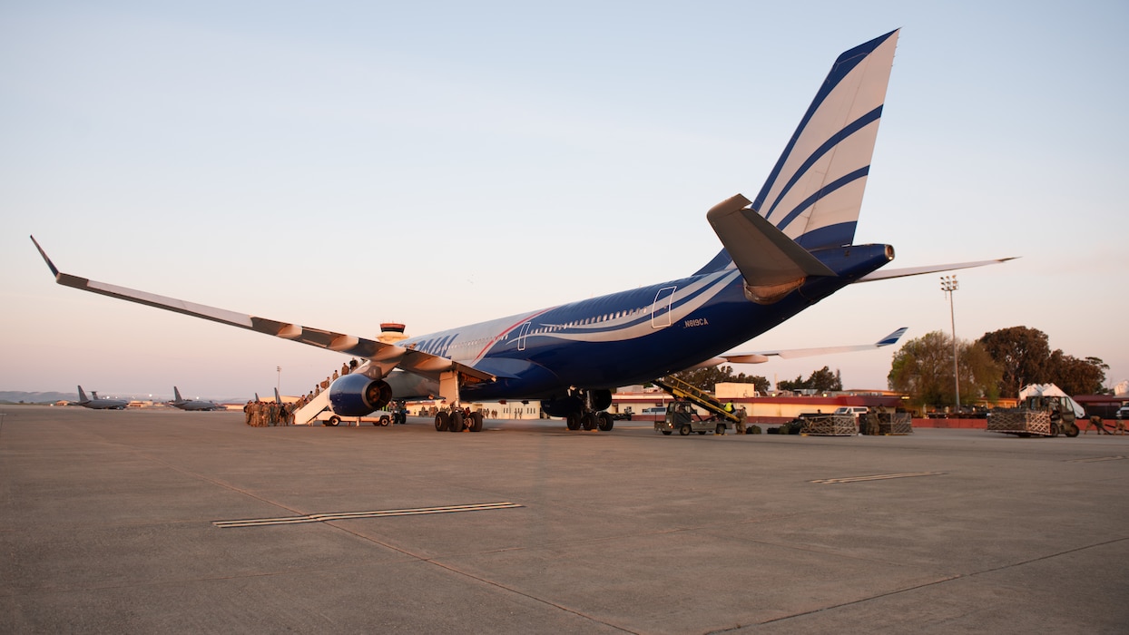 Airmen load onto commercial aircraft on flight line