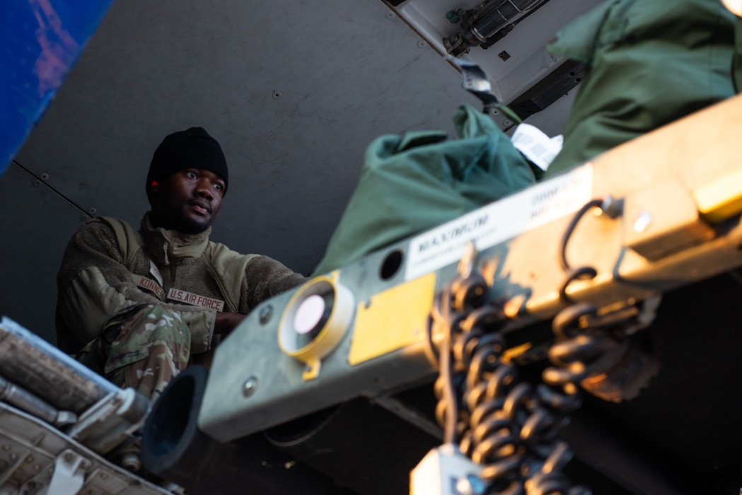 Airman loading bags off cargo belt