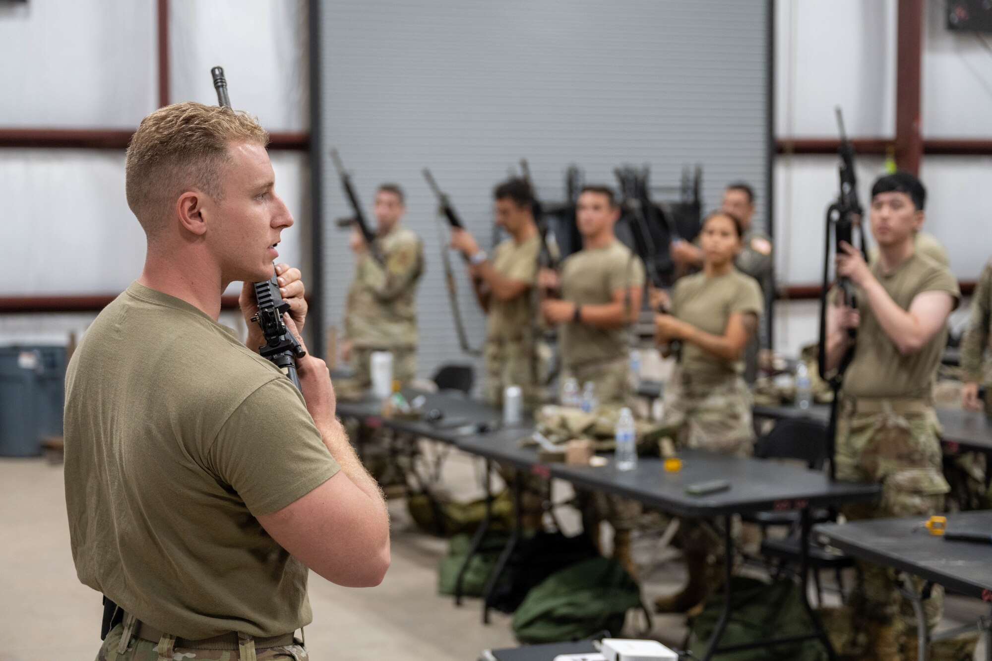 A U.S. Air Force weapons instructor demonstrates proper handling of an M4 assault rifle to a class of Airmen during Warrior Airmen Training.