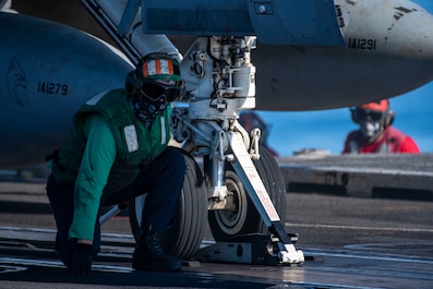 PHILIPPINE SEA (April 22, 2025) — A Sailor awaits confirmation to signal the seating of the catapult onto an F/A-18F Super Hornet from the 