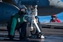 A Sailor awaits confirmation to signal the seating of the catapult onto an F/A-18F Super Hornet from the "Kestrels" of Strike Fighter Squadron (VFA) 137 before launching from the flight deck of the aircraft carrier USS Nimitz (CVN 68) in the Philippine Sea, April 22, 2025.