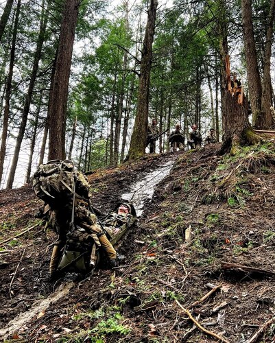 A Soldier practices evacuating a casualty on a steep slope